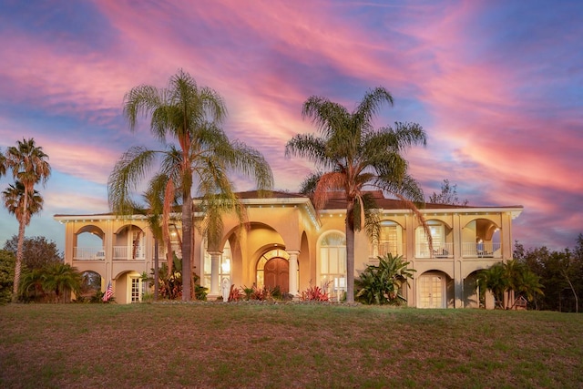 mediterranean / spanish house with a front yard and a balcony