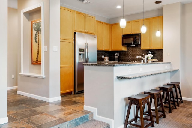 kitchen with tasteful backsplash, light brown cabinets, black microwave, and stainless steel fridge with ice dispenser