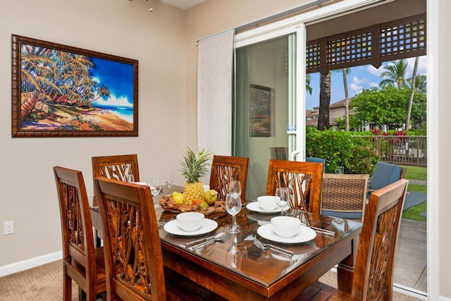 carpeted dining space with baseboards