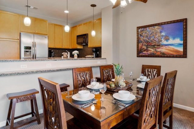 dining room featuring visible vents, baseboards, ceiling fan, and carpet floors