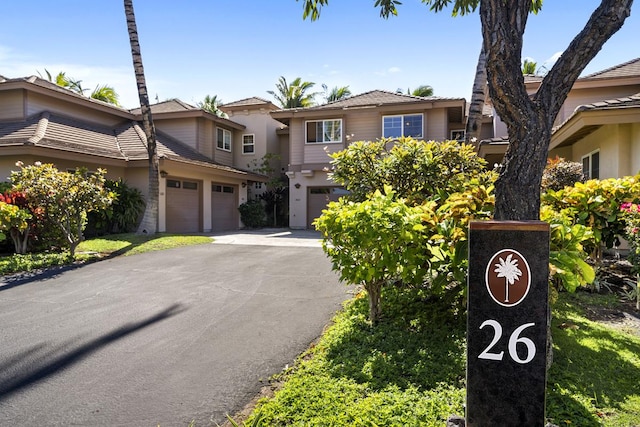 view of front of property featuring an attached garage, driveway, and stucco siding