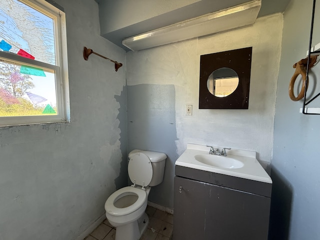 half bathroom with vanity, toilet, and tile patterned flooring