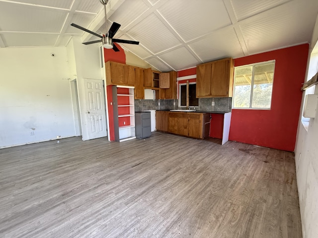 kitchen featuring tasteful backsplash, brown cabinets, lofted ceiling, and wood finished floors