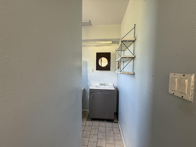 hallway featuring baseboards and a sink