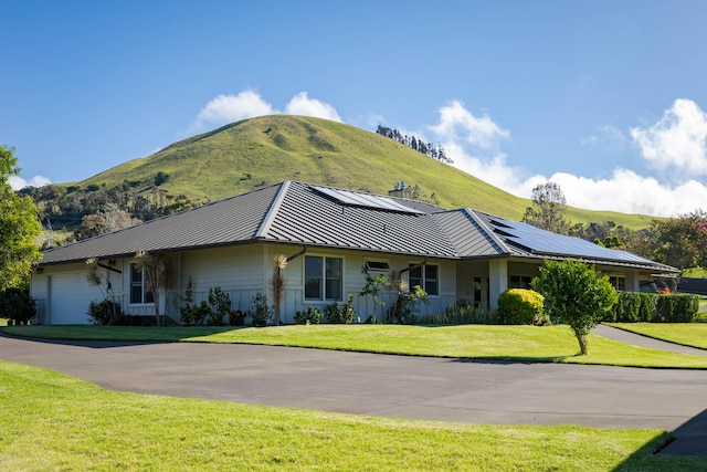 view of side of home featuring an attached garage, a mountain view, metal roof, and a standing seam roof