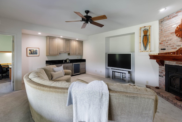 living area with light colored carpet, wet bar, a fireplace, a ceiling fan, and beverage cooler
