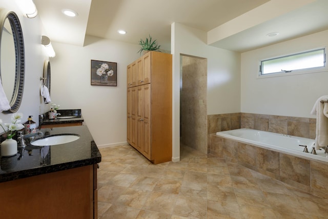 full bathroom with a bath, vanity, and recessed lighting