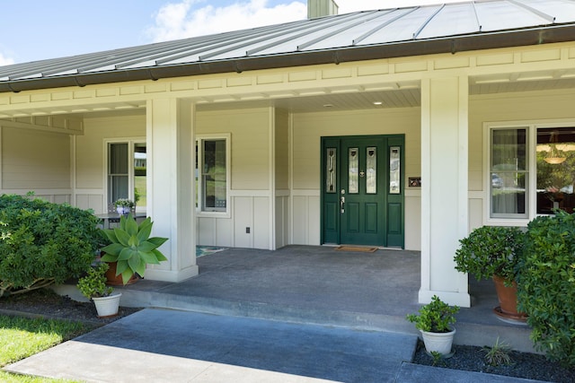 property entrance with a porch, metal roof, a standing seam roof, and board and batten siding