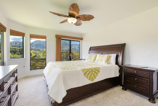 bedroom with light carpet, a mountain view, a ceiling fan, and access to outside