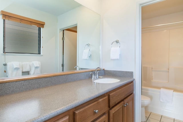 bathroom featuring toilet, bathtub / shower combination, vanity, and tile patterned flooring