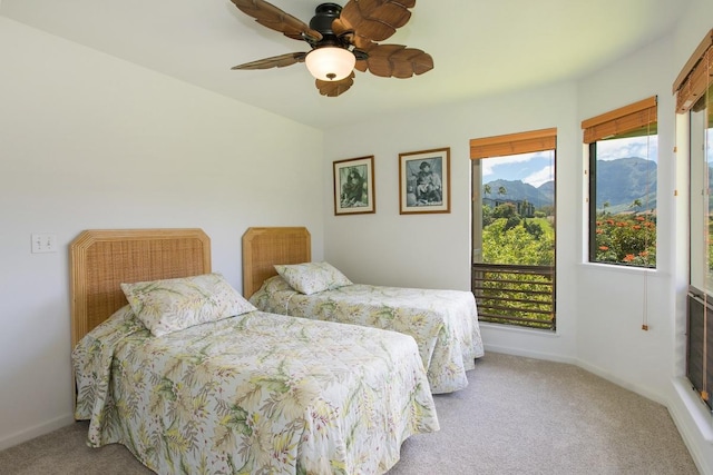 bedroom with a mountain view, baseboards, a ceiling fan, and carpet flooring