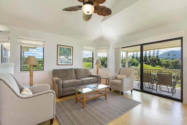 living area with lofted ceiling, wood finished floors, a mountain view, and ceiling fan