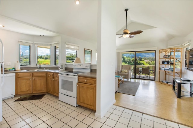 kitchen with white appliances, light tile patterned floors, lofted ceiling, ceiling fan, and a sink