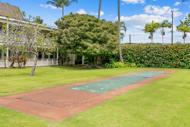 view of community featuring shuffleboard and a yard