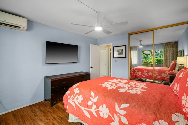 bedroom with a closet, an AC wall unit, a ceiling fan, and wood finished floors