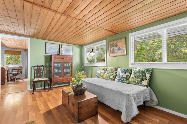 bedroom with wood ceiling, baseboards, and wood finished floors