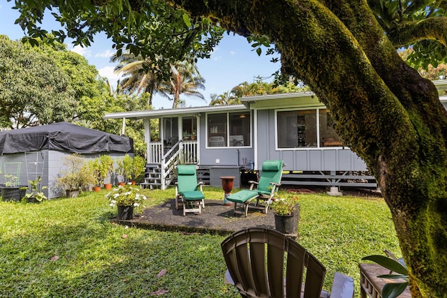 rear view of house with a lawn and board and batten siding