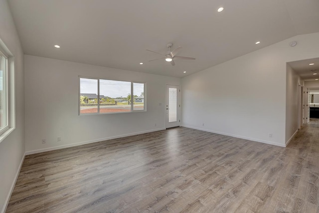 spare room with baseboards, light wood-type flooring, lofted ceiling, recessed lighting, and a ceiling fan