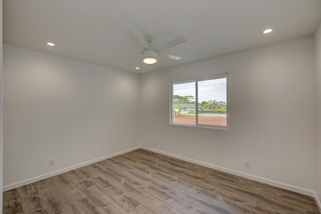 empty room with recessed lighting, baseboards, and wood finished floors