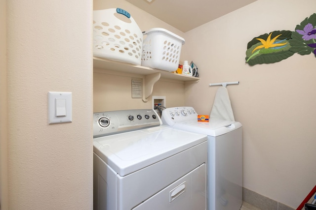 washroom with laundry area, independent washer and dryer, and baseboards