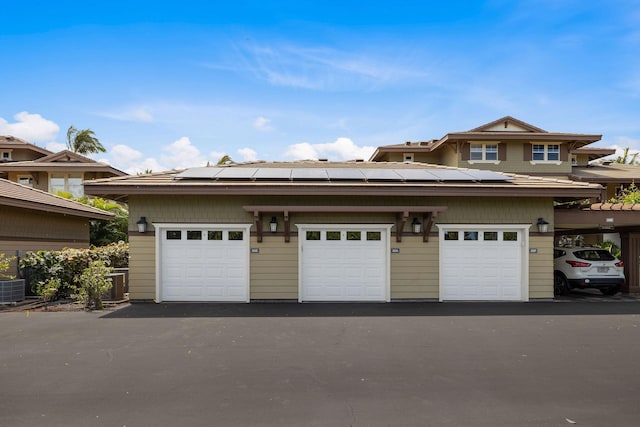 view of front of property featuring a garage and roof mounted solar panels