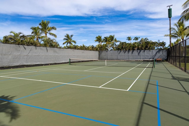 view of tennis court with community basketball court and fence