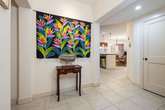 hallway featuring light tile patterned floors, a notable chandelier, recessed lighting, and baseboards