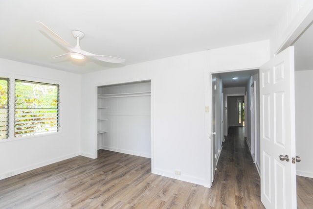 unfurnished bedroom with a closet, ceiling fan, baseboards, and wood finished floors