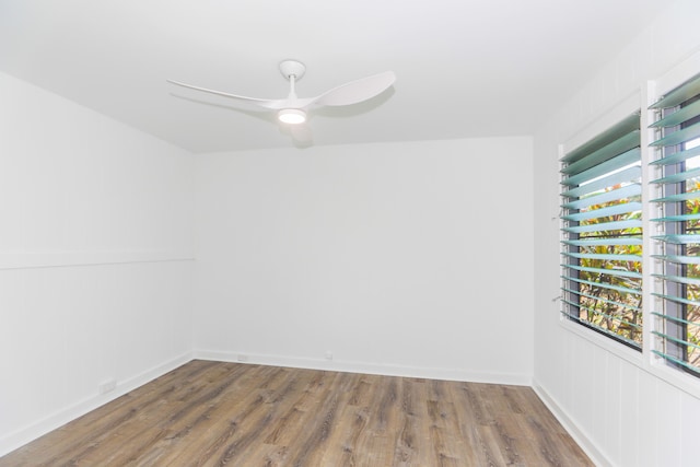 empty room with baseboards, ceiling fan, and wood finished floors