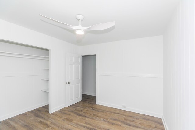 unfurnished bedroom featuring a closet, baseboards, ceiling fan, and wood finished floors