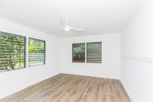 empty room with baseboards, light wood-style floors, and a ceiling fan