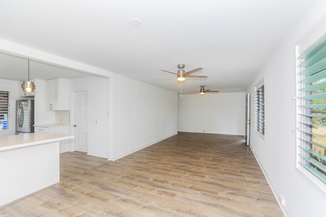 unfurnished living room with light wood finished floors and ceiling fan