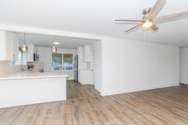 kitchen featuring white cabinetry, appliances with stainless steel finishes, wood finished floors, and light countertops