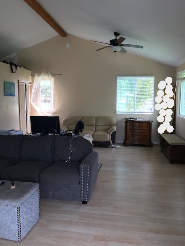 living area with light wood-type flooring, lofted ceiling with beams, and ceiling fan