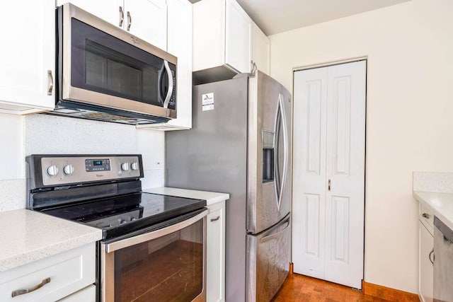 kitchen featuring stainless steel appliances, light countertops, and white cabinetry