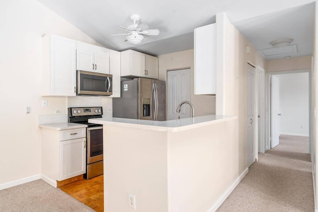 kitchen featuring white cabinets, appliances with stainless steel finishes, light colored carpet, and ceiling fan