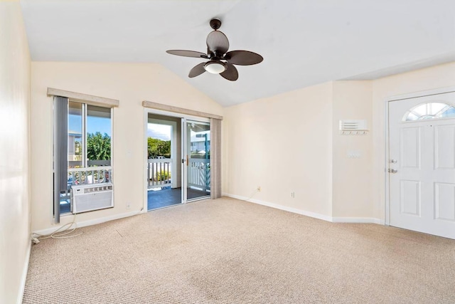 carpeted spare room featuring lofted ceiling, cooling unit, baseboards, and ceiling fan