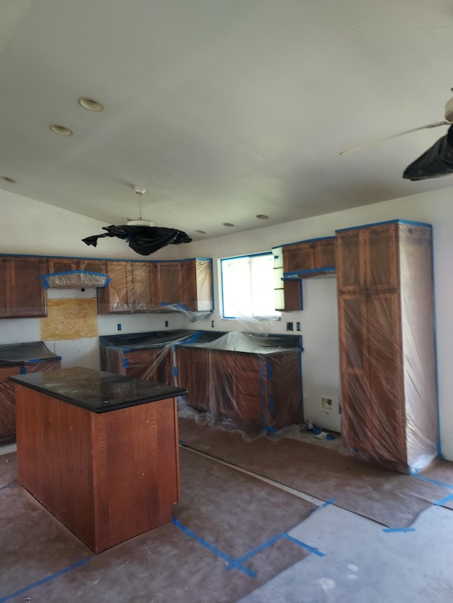 kitchen with dark countertops, a center island, and exhaust hood