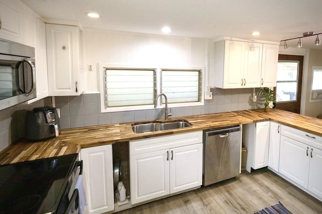 kitchen featuring a sink, white cabinets, stainless steel appliances, and butcher block counters