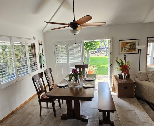 tiled dining room with baseboards, ceiling fan, and vaulted ceiling