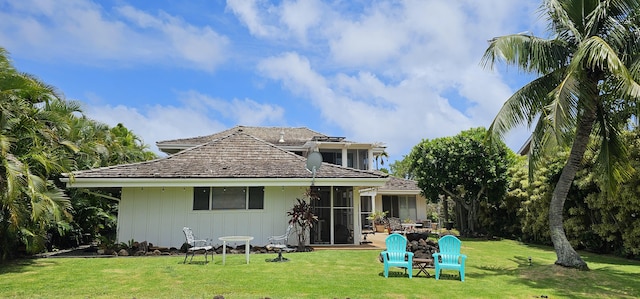 rear view of house with a lawn and board and batten siding