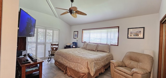 tiled bedroom with lofted ceiling and a ceiling fan