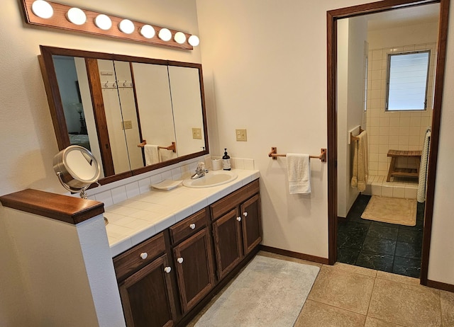 bathroom with baseboards, vanity, and tile patterned flooring