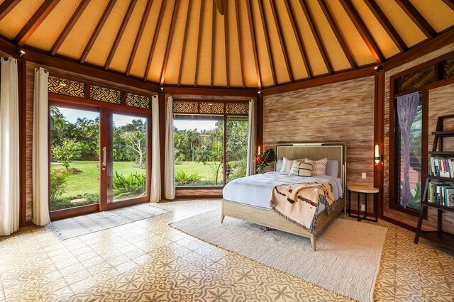 unfurnished bedroom with access to exterior, high vaulted ceiling, and wood walls
