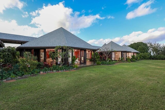 back of property featuring a yard