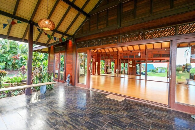 unfurnished sunroom featuring plenty of natural light and beam ceiling