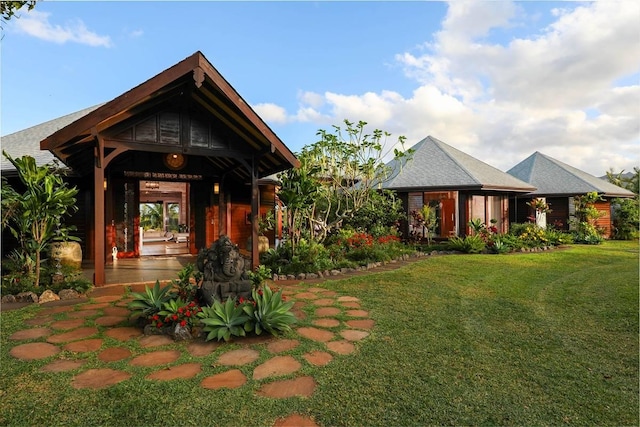 exterior space featuring a shingled roof and a yard