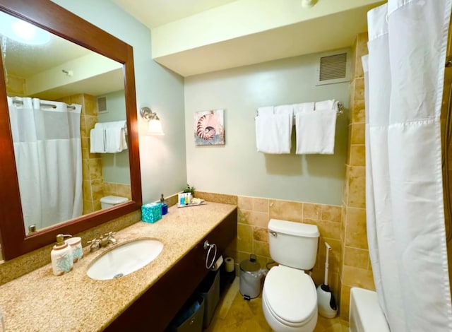 bathroom with visible vents, tile walls, toilet, a shower with shower curtain, and vanity