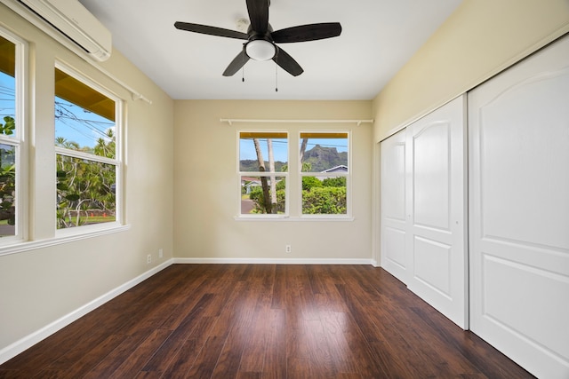 210 Eggerking Rd, Kapaa, HI 96746 - unfurnished bedroom featuring an AC wall unit, dark wood-type flooring, baseboards, and a closet