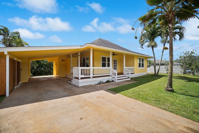 210 Eggerking Rd, Kapaa, HI 96746 - country-style home with concrete driveway, covered porch, a front lawn, board and batten siding, and a carport